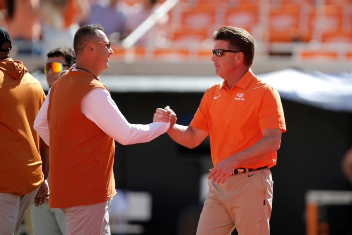 Texas Longhorns head coach Steve Sarkisian, left, and Oklahoma State Cowboys head coach Mike Gundy talk before a college football game between the Oklahoma State Cowboys (OSU) and the University of Texas at Austin Longhorns.